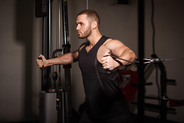 Sporty sexy men with great abdominal muscles in black sportswear working out in the gym