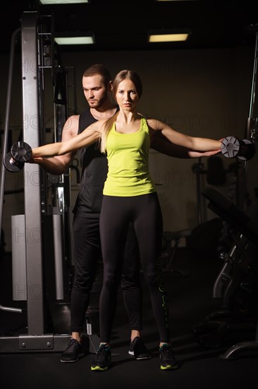 Sporty sexy man and woman with great abdominal muscles in black sportswear