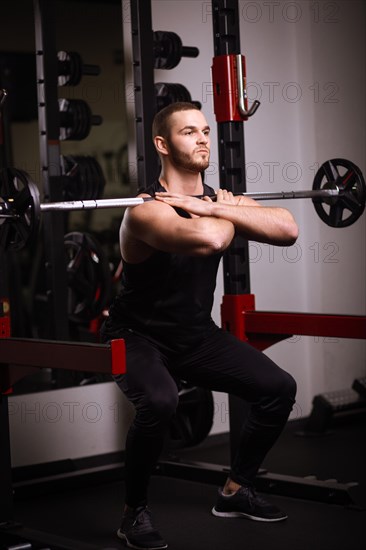 Sporty sexy men with great abdominal muscles in black sportswear working out in the gym