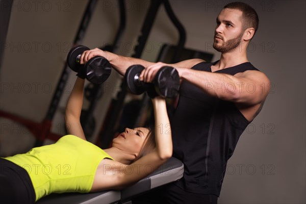 Sporty sexy man and woman with great abdominal muscles in black sportswear