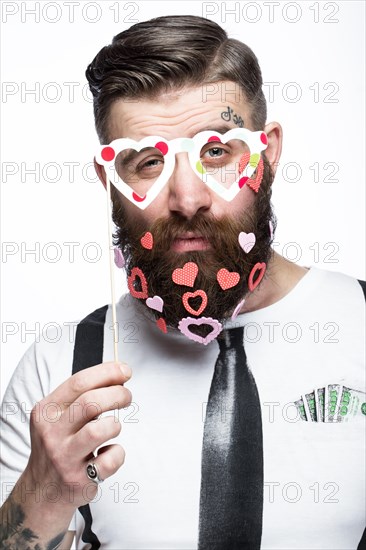 Funny bearded man with hearts Valentine's Day. Portrait shot in studio