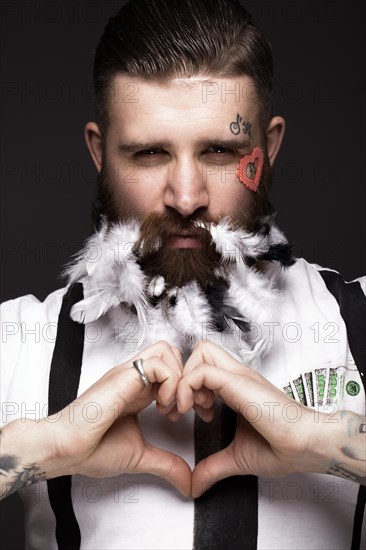 Funny bearded man with feathers and wings in the image of Cupid Valentine's Day. Portrait shot in studio