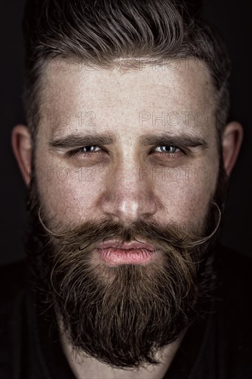 A solid man with a beard and mustache. Photos shot in the studio