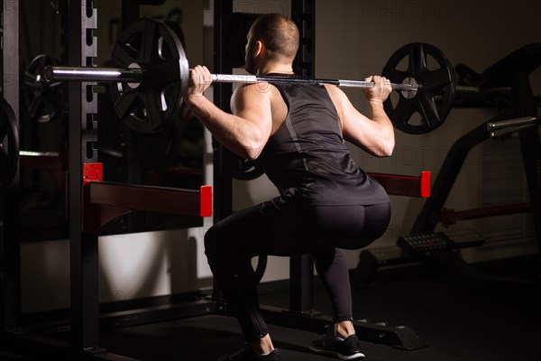 Sporty sexy men with great abdominal muscles in black sportswear working out in the gym