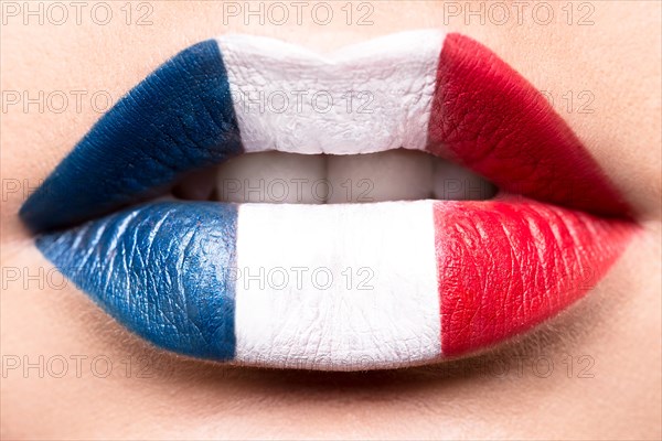 Female lips close up with a picture of the flag of France. Blue