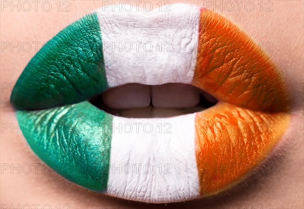 Female lips close up with a picture flag of Ireland. Green