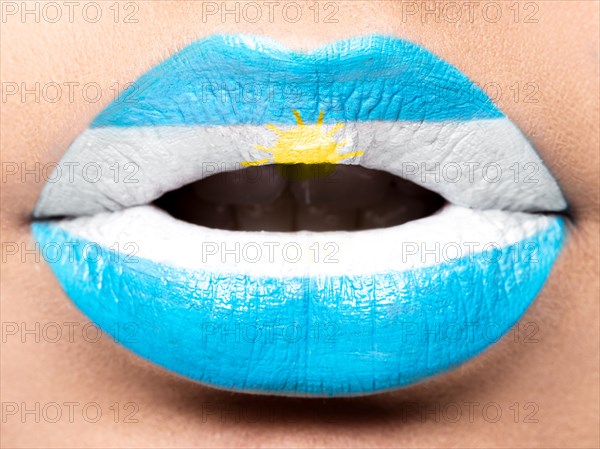 Female lips close up with a picture of the flag of Argentina. White