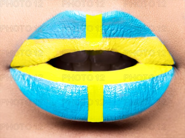 Female lips close up with a picture of the flag of Sweden. blue