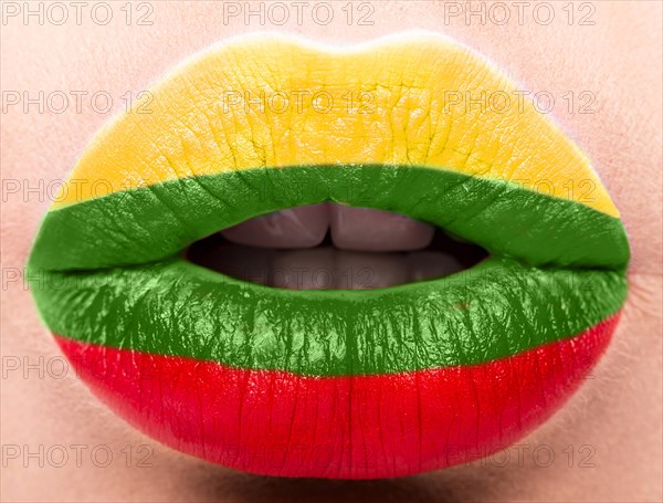 Female lips close up with a picture of the flag of Lithuania. Yellow