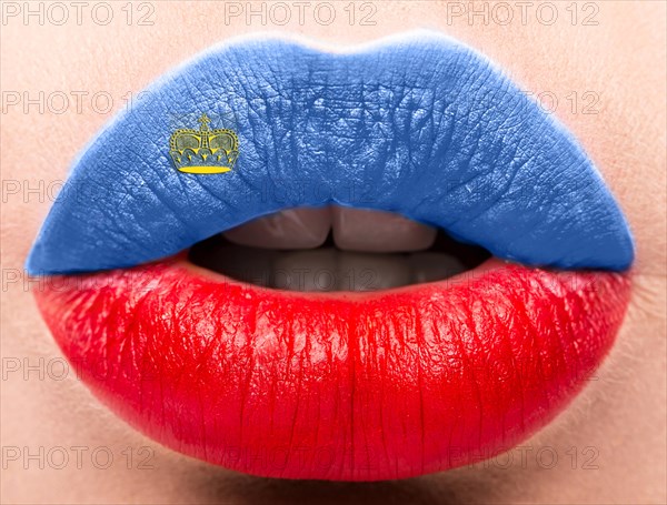Female lips close up with a picture of the flag of Liechtenstein. Blue