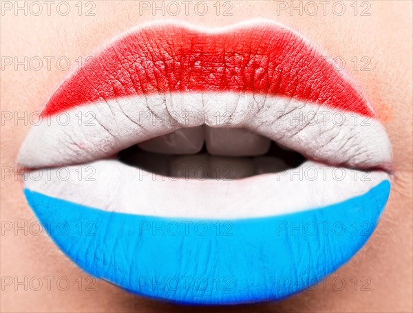 Female lips close up with a picture of the flag of Luxembourg. Blue