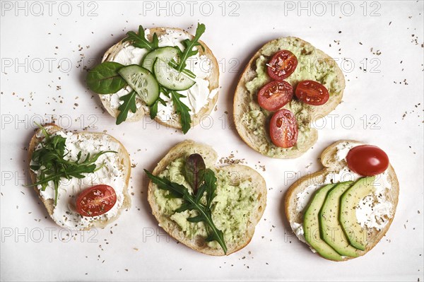 Vegan sandwiches with curd cheese and vegetables on wooden background