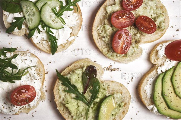 Vegan sandwiches with curd cheese and vegetables on wooden background