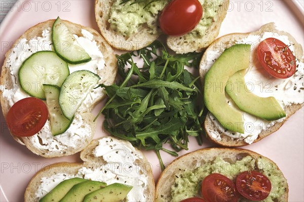 Vegan sandwiches with curd cheese and vegetables on wooden background