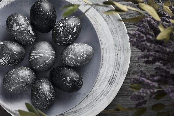 Black painted eggs for Easter on a blue plate