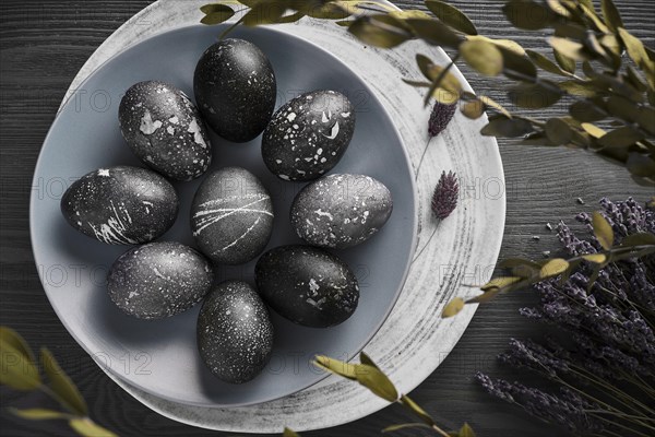 Black painted eggs for Easter on a blue plate