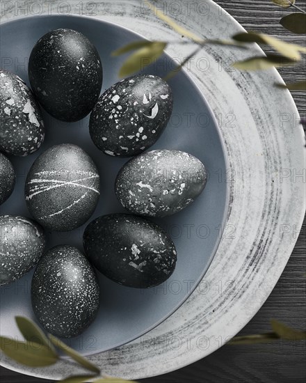 Black painted eggs for Easter on a blue plate