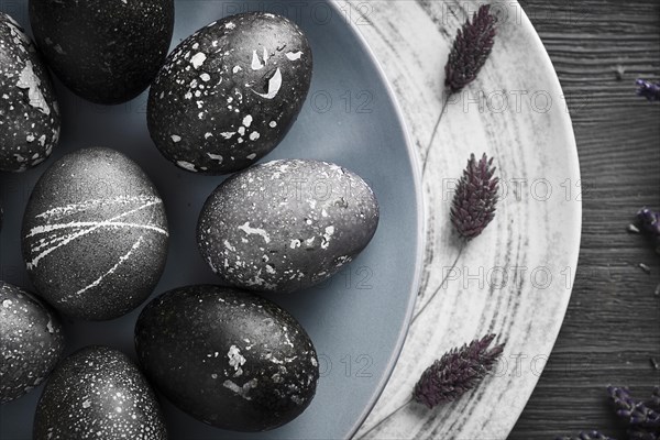 Black painted eggs for Easter on a blue plate