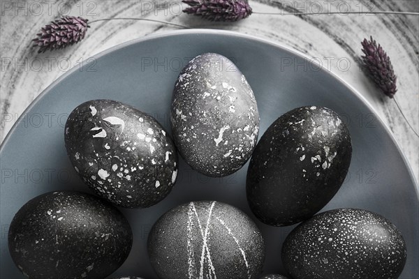 Black painted eggs for Easter on a blue plate
