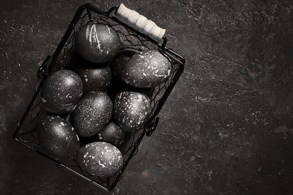 Black painted eggs for Easter in a basket