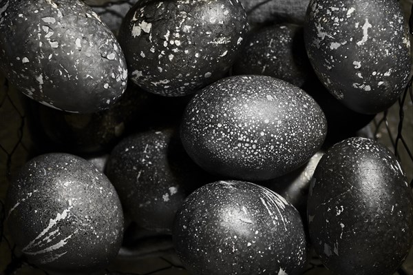 Black painted eggs for Easter in a basket