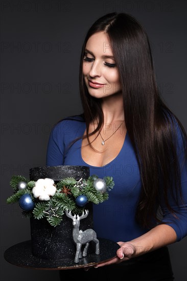 Beautiful woman pastry chef in a blue dress with a Christmas cake in her hands