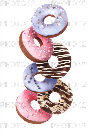 Sweet multicolored donuts on a white background in levitation