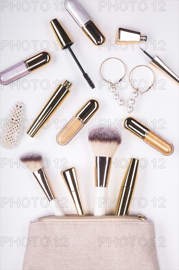 Set of brushes and cosmetic products in a cosmetic bag on a white background