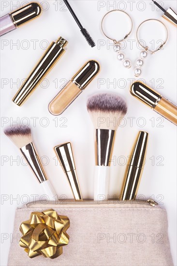 Set of brushes and cosmetic products in a cosmetic bag on a white background