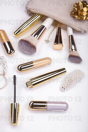 Set of brushes and cosmetic products in a cosmetic bag on a white background