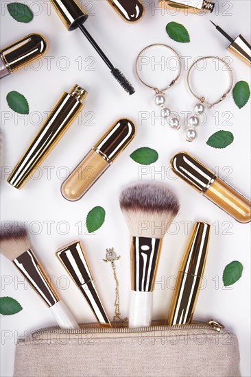 Set of brushes and cosmetic products in a cosmetic bag on a white background