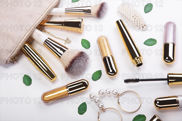 Set of brushes and cosmetic products in a cosmetic bag on a white background