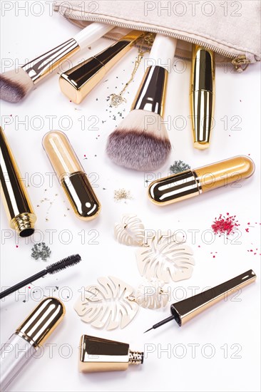 Set of brushes and cosmetic products in a cosmetic bag on a white background