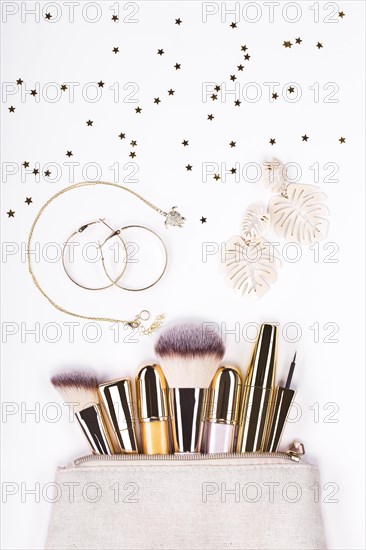 Set of brushes and cosmetic products in a cosmetic bag on a white background