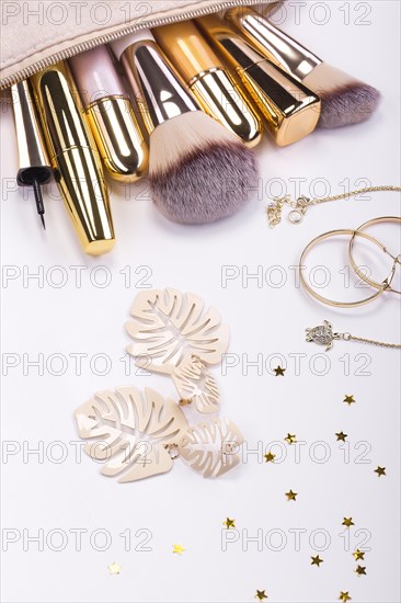 Set of brushes and cosmetic products in a cosmetic bag on a white background