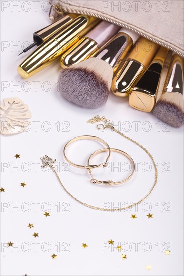 Set of brushes and cosmetic products in a cosmetic bag on a white background