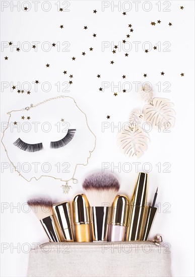 Set of brushes and cosmetic products in a cosmetic bag on a white background