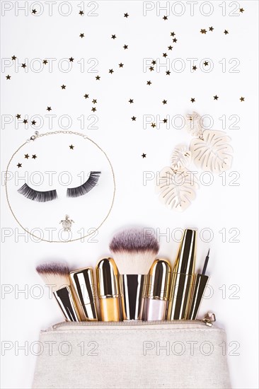 Set of brushes and cosmetic products in a cosmetic bag on a white background