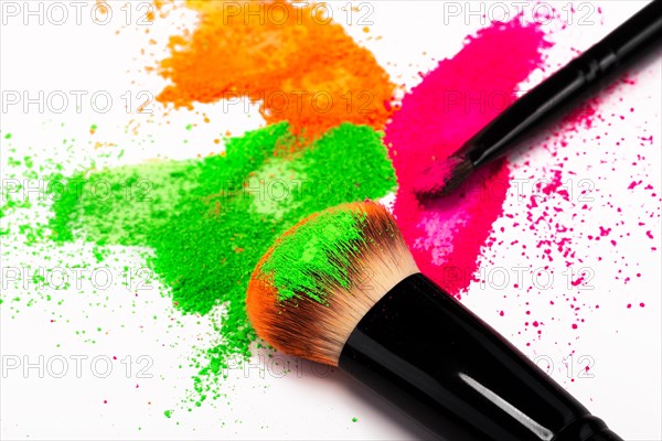 Cheek brush with neon cosmetic powder colorful pile and isolated on white background