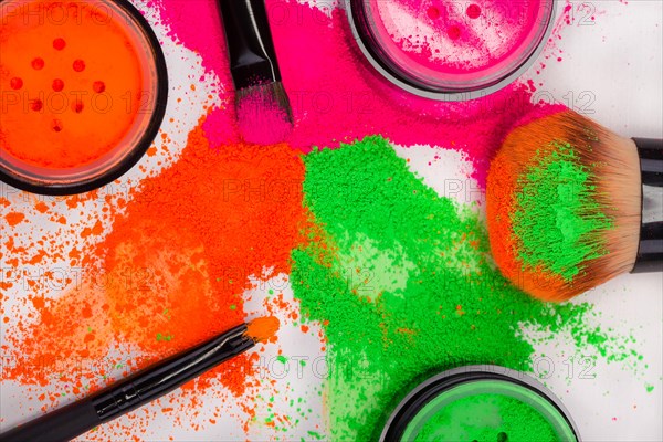 Cheek brush with neon cosmetic powder colorful pile and isolated on white background