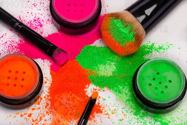 Cheek brush with neon cosmetic powder colorful pile and isolated on white background