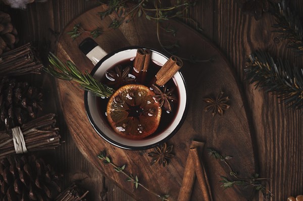 Christmas hot drink mulled wine on wooden background with cinnamon