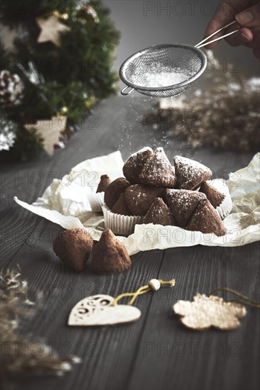 Simple Christmas truffle candy on a wooden background with plant branches
