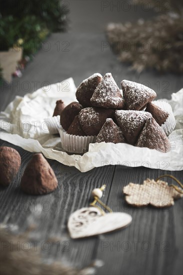 Simple Christmas truffle candy on a wooden background with plant branches