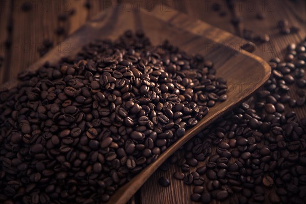 Grains of roasted coffee in the shape of a heart on a white plate