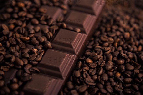 Roasted coffee beans and chocolate bar close-up