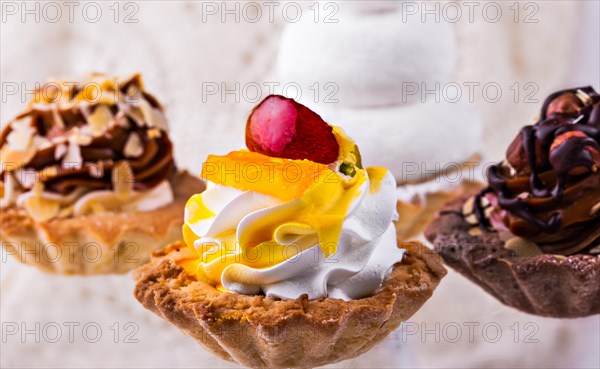Tasty cakes on a transparent plate on a background of a white tablecloth
