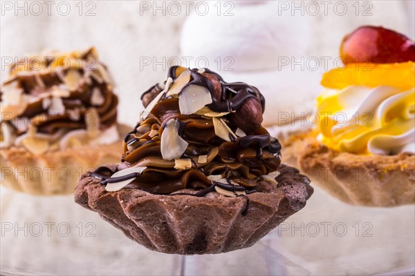 Tasty cakes on a transparent plate on a background of a white tablecloth