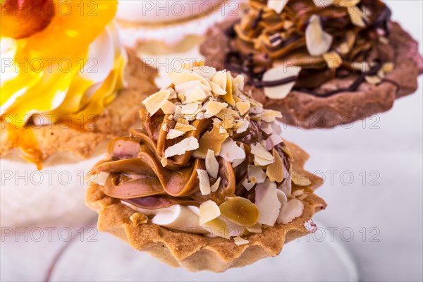 Tasty cakes on a transparent plate on a background of a white tablecloth