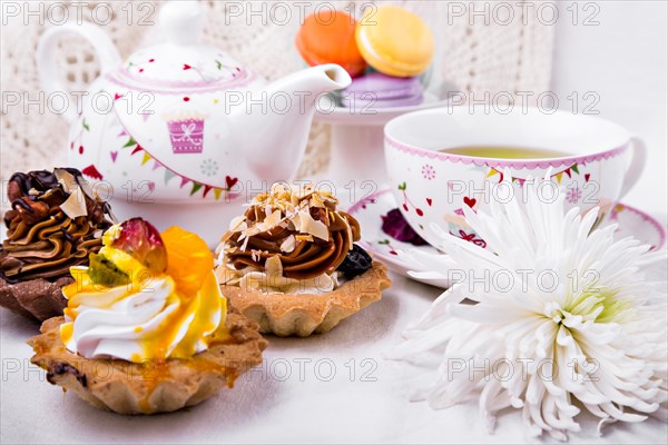 Tasty and delicious cake with a cup of green tea on a white tablecloth